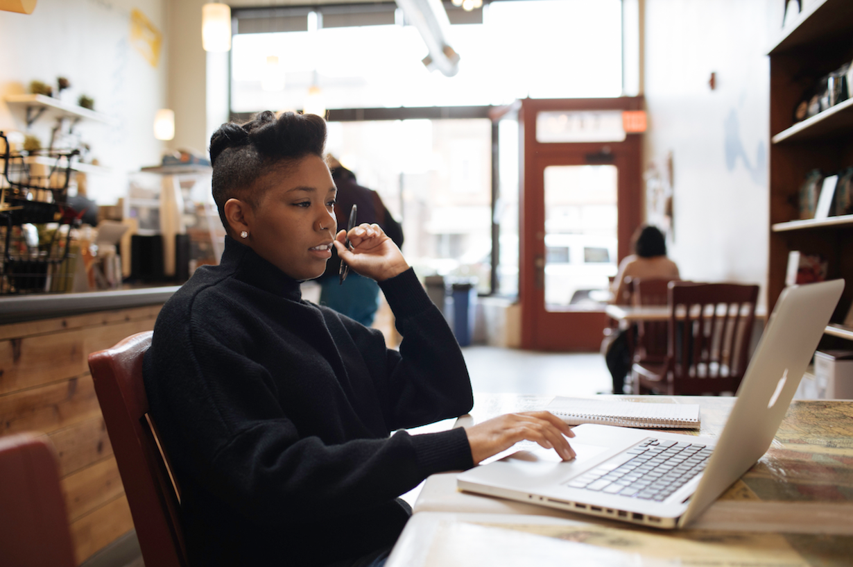 一位年轻的企业家在咖啡店里用笔记本电脑工作.